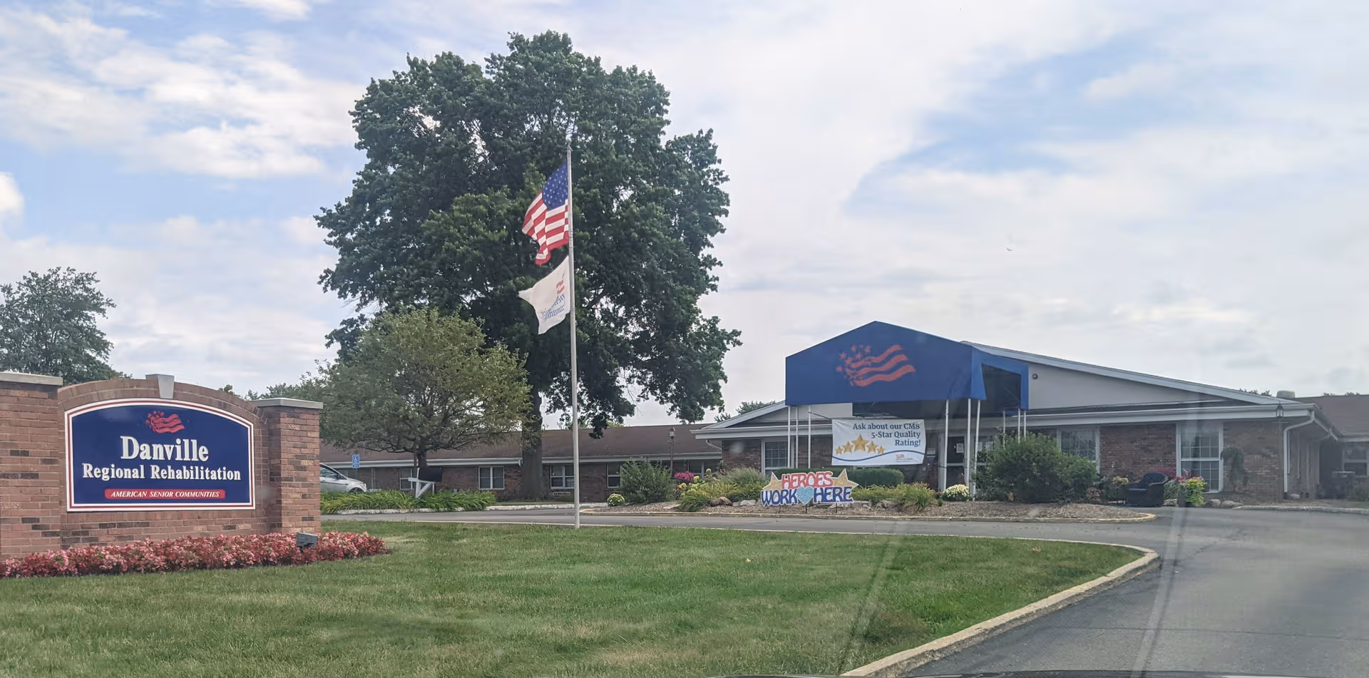 Exterior view of Danville Regional Rehabilitation facility with American flag, sign, and landscaping.