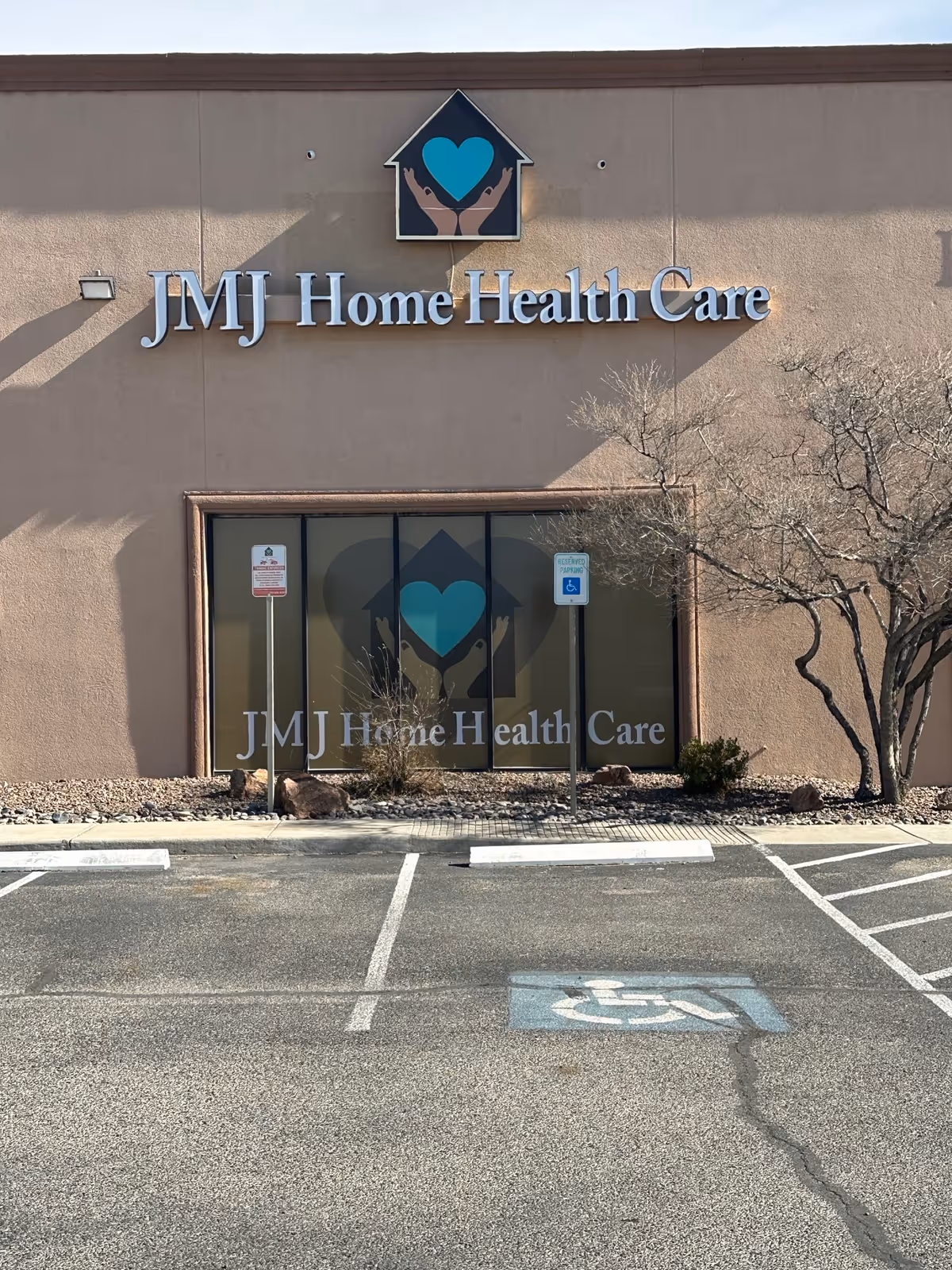 Front exterior of JMJ Home Health Care building with glass doors and handicap parking.