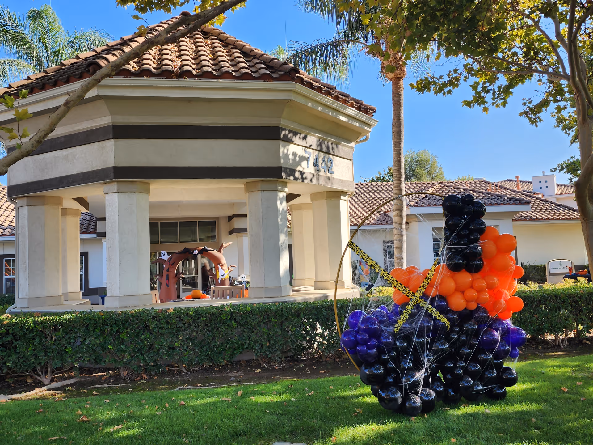 Exterior view of a covered entrance at Westmont of Fresno with balloons.