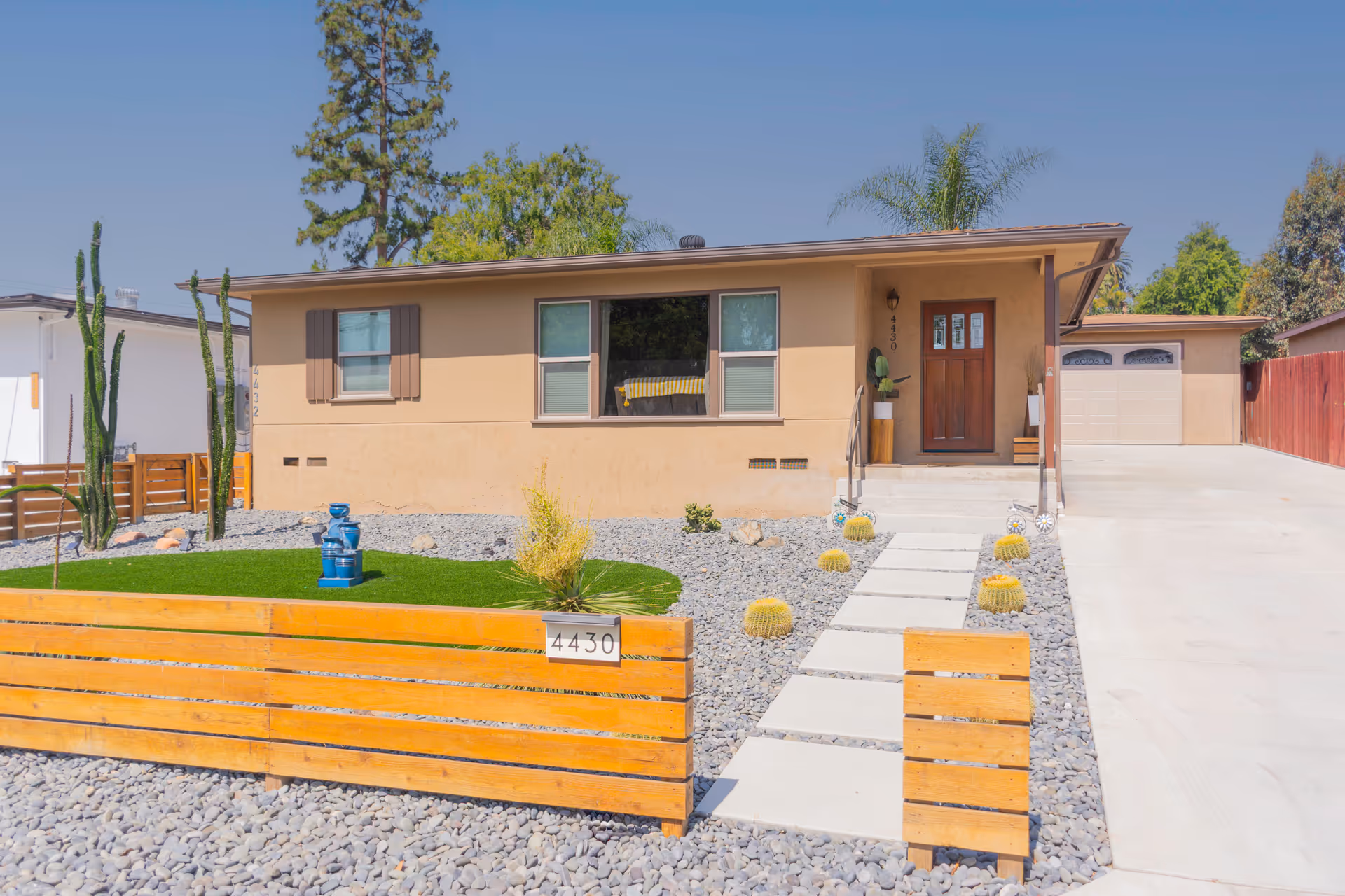 Single-story beige assisted living home with desert landscaping, wooden fence, and concrete driveway.