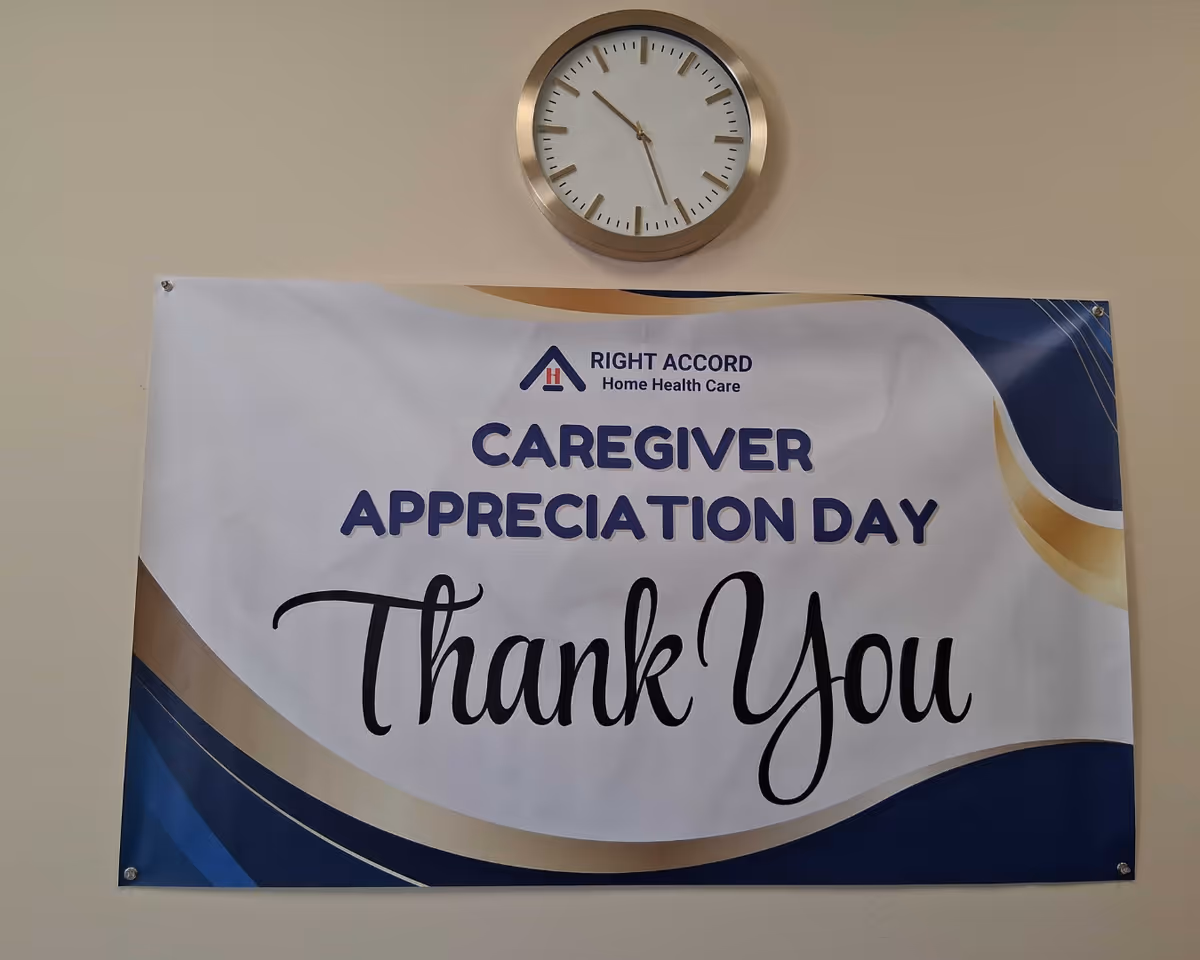 Clock above a banner that says Caregiver Appreciation Day Thank You in an interior hallway.