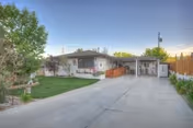 Front view of a single-story senior living home with driveway and covered carport.
