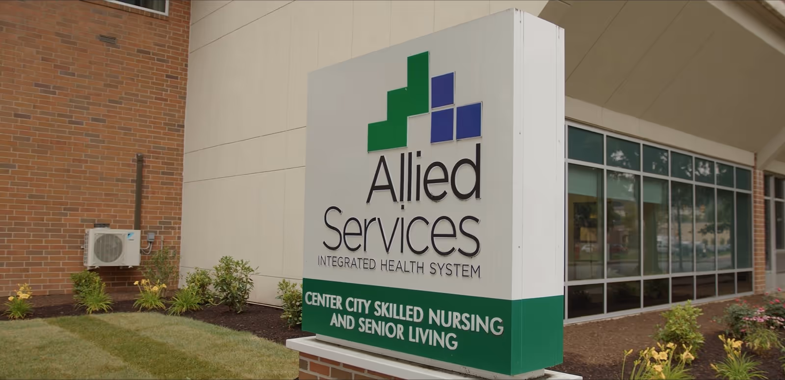 Exterior view of Allied Services facility with a large front sign and glass entrance.