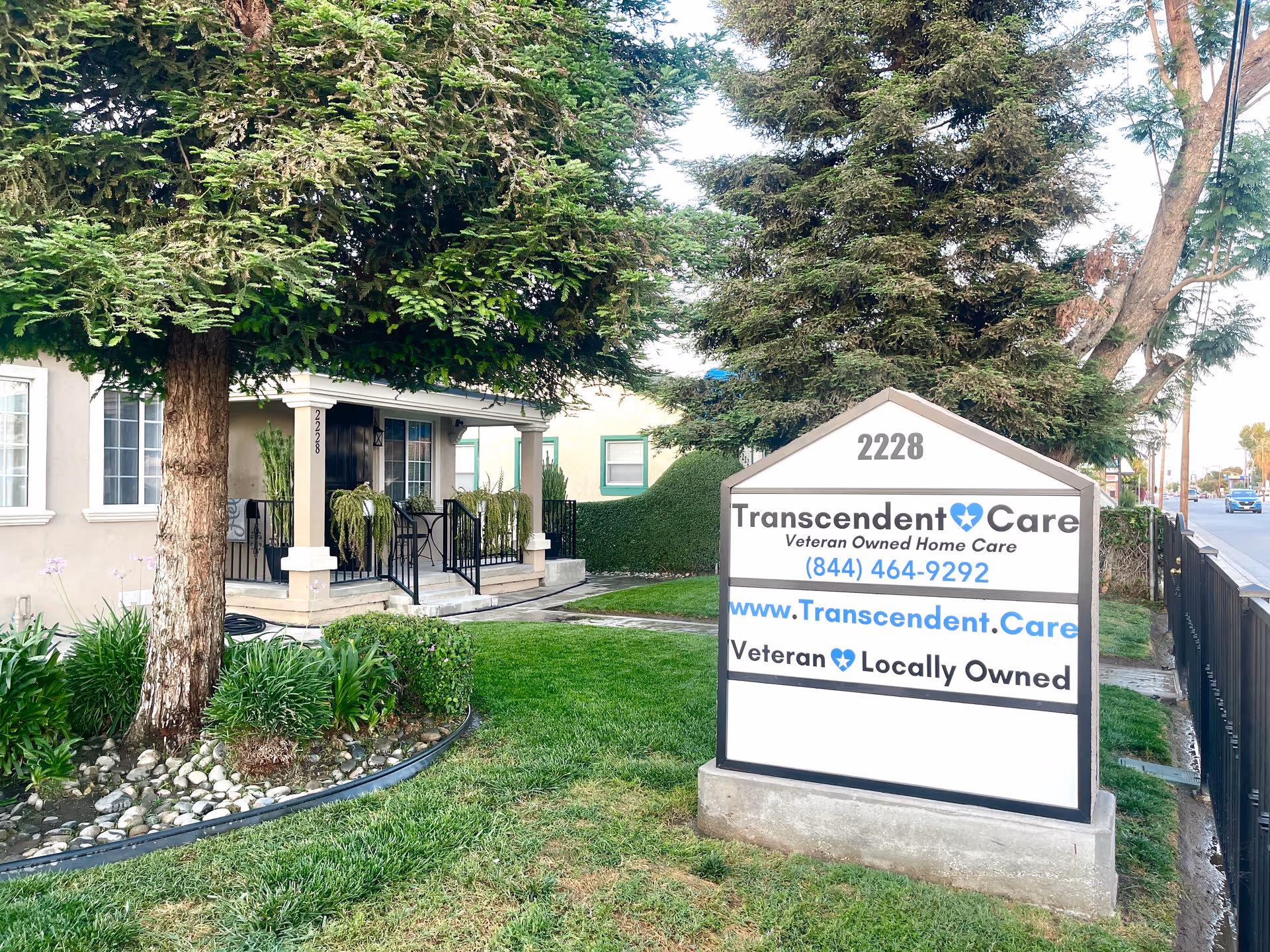 Exterior view of Transcendent Care facility with manicured lawn and front sign.