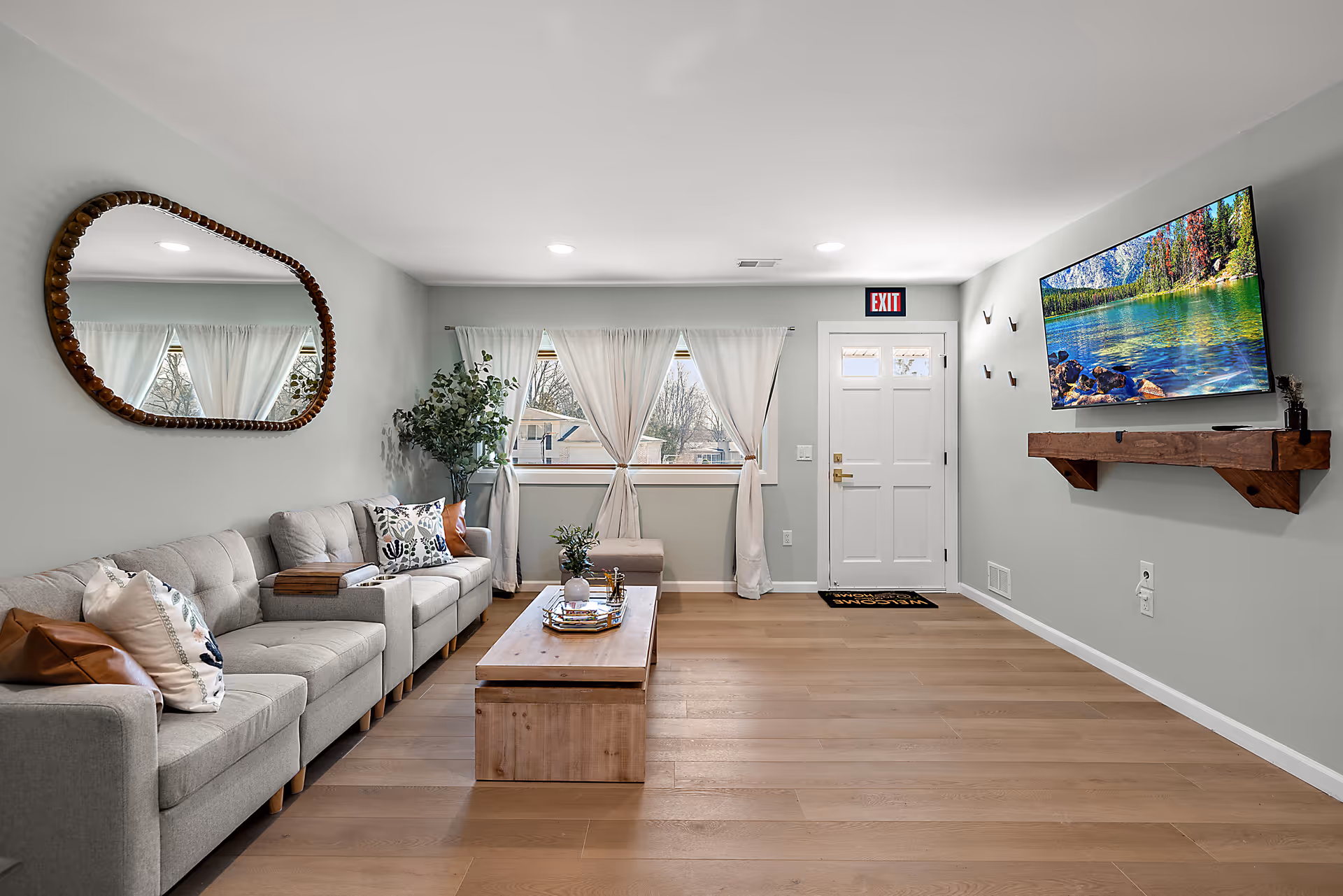 Spacious living room in Amor Novi Boutique Senior Living with sofa, TV, and plants.