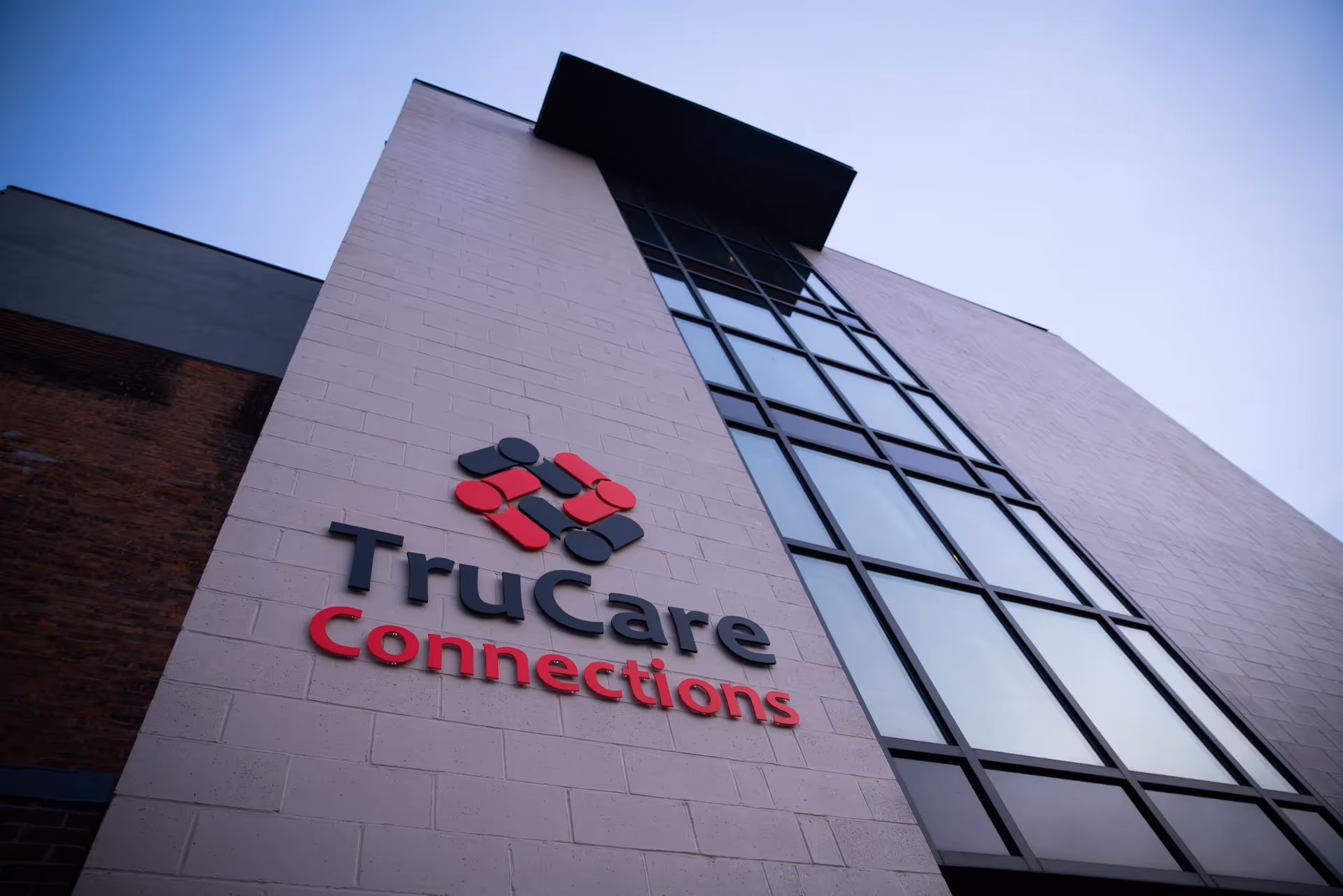 Low-angle view of TruCare Connections building exterior with its logo.
