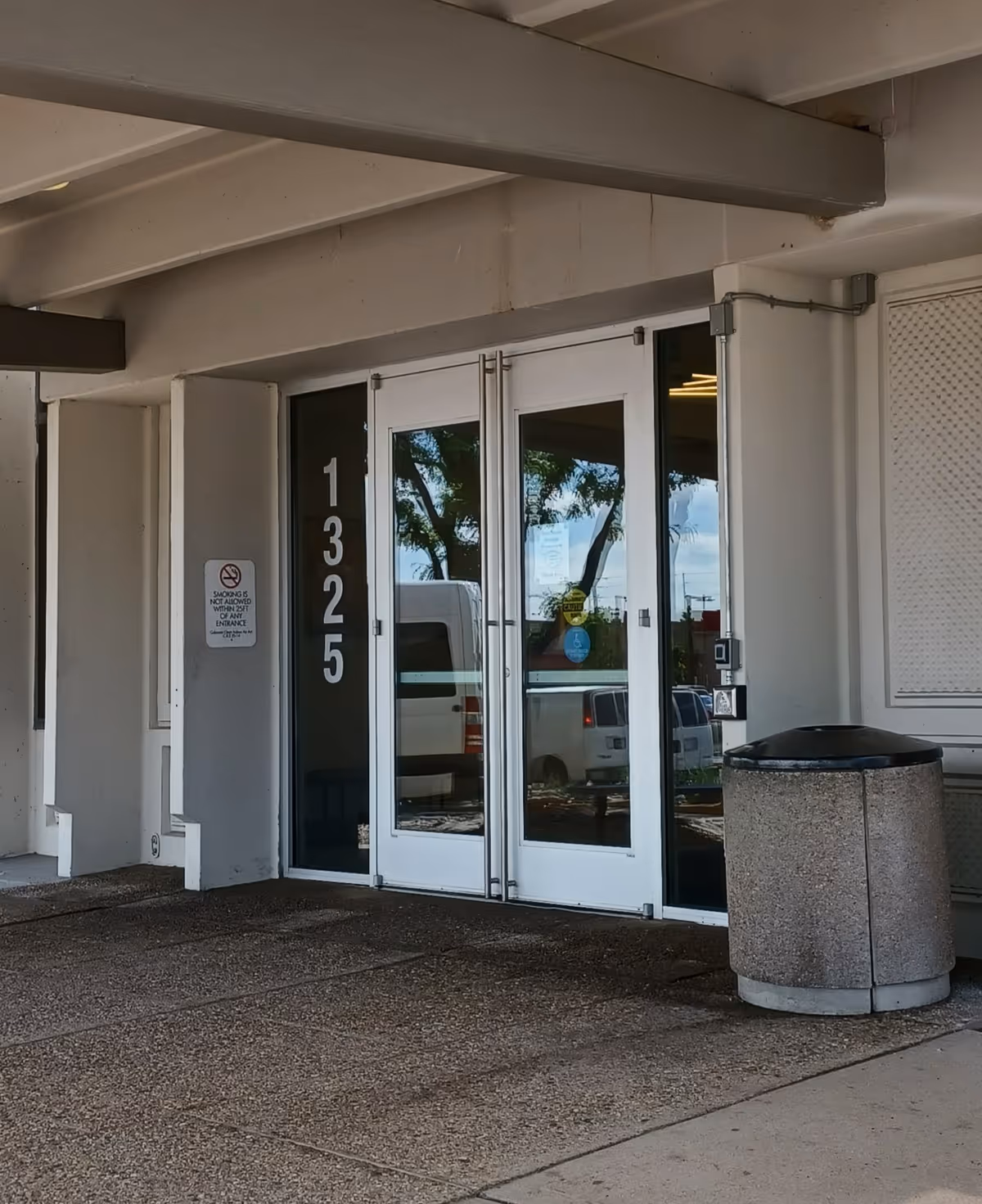Exterior entrance with glass doors and tall vertical numbers 1325 on the front of the building.