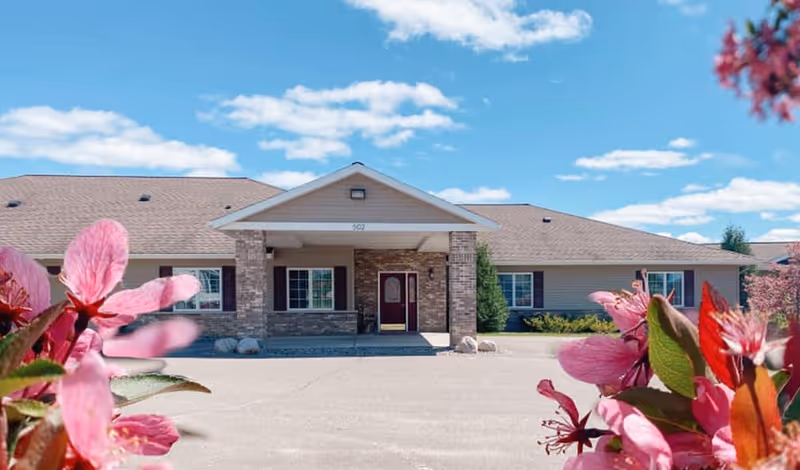 Front view of Carefree Living Buhl facility with flower foreground and entrance.