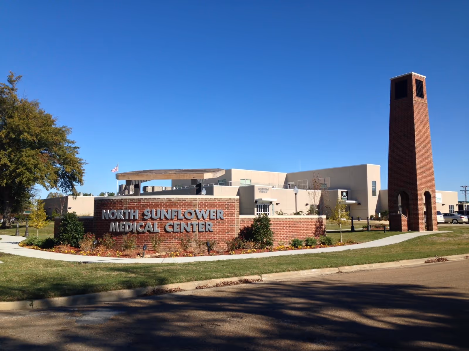 Exterior view of a medical facility with a brick sign reading North Sunflower Medical Center.