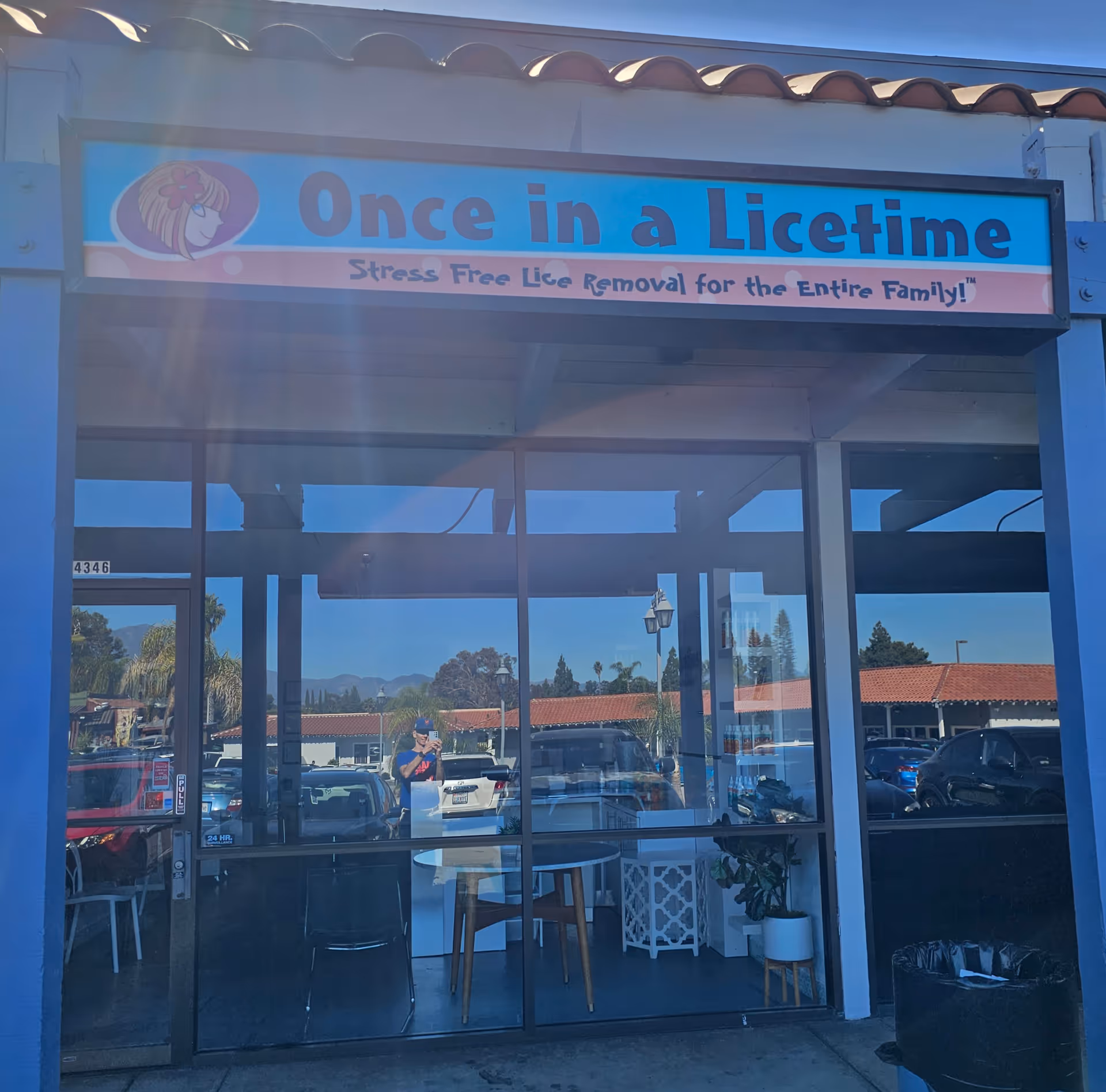 Front view of a storefront with 'Once in a Licetime' sign above glass doors.