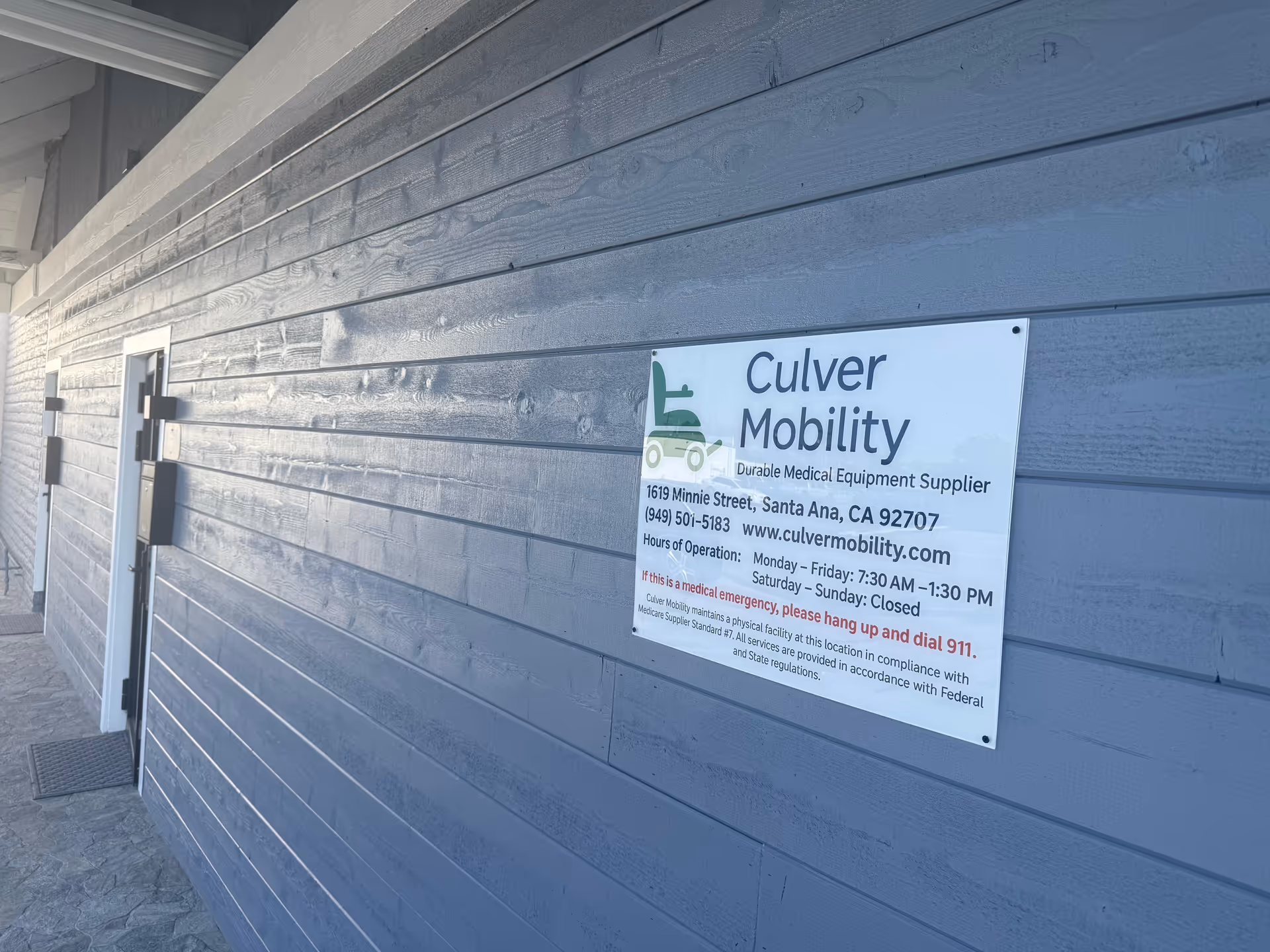 Blue exterior wall with Culver Mobility sign and doorway.