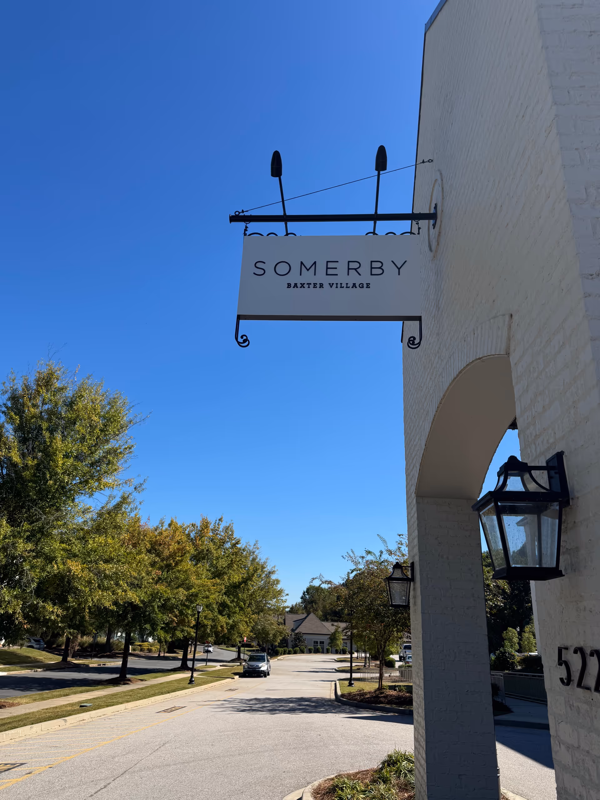 Exterior view of a building front with a hanging sign for Somerby Baxter Village.