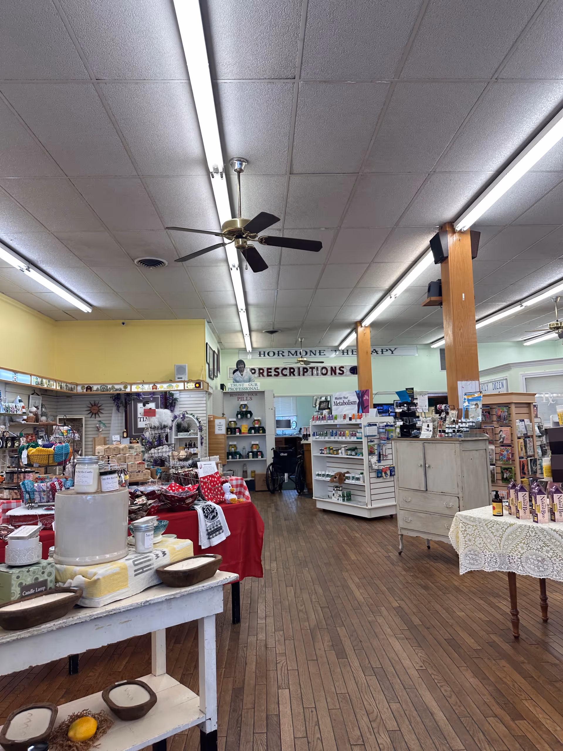 Interior of a store-like common area with shelves, tables, and assorted merchandise.