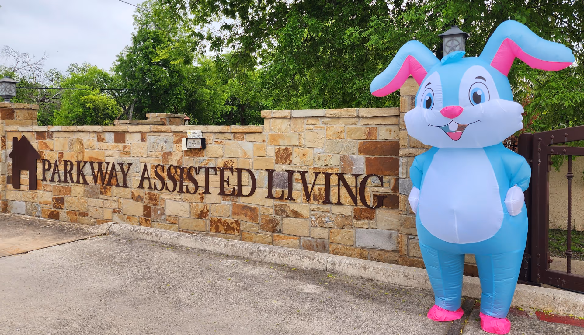 Exterior view of Parkway Assisted Living entrance with a stone wall and inflatable bunny.
