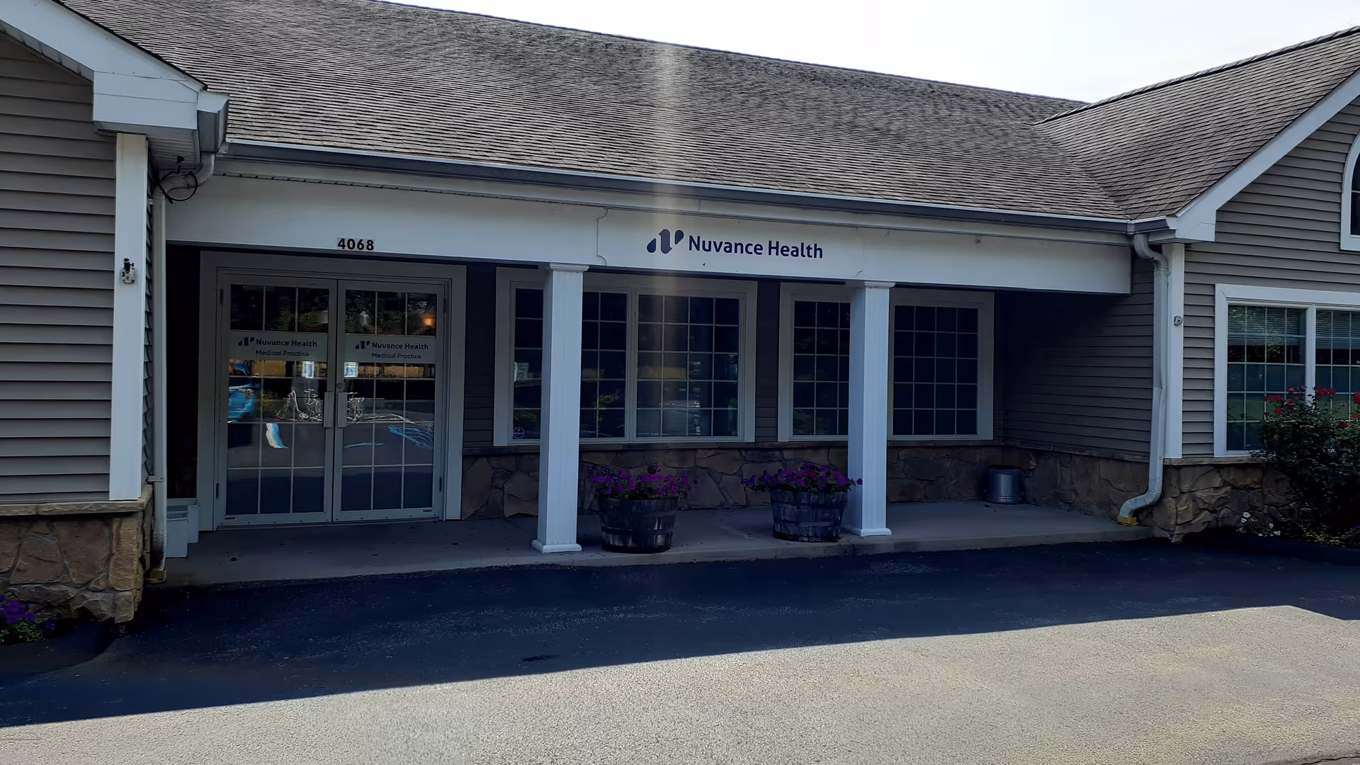 Front exterior of Nuvance Health Primary Care Hyde Park with glass doors and sign.