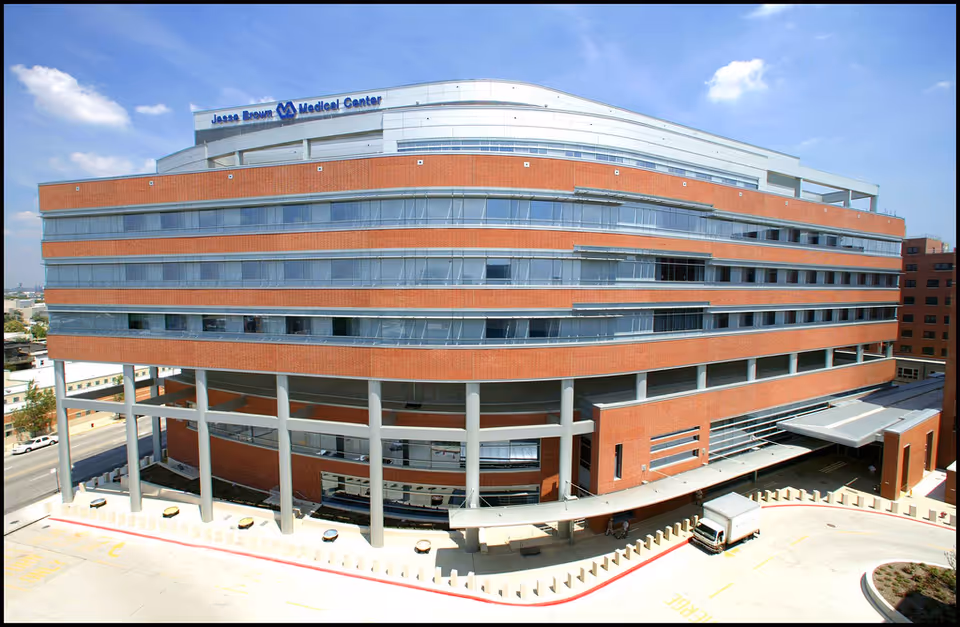 A large brick and glass medical center building with a curved facade and multiple levels.