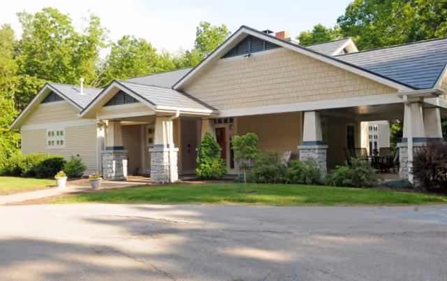 Exterior of a single-story building with a covered entrance and landscaped grounds.