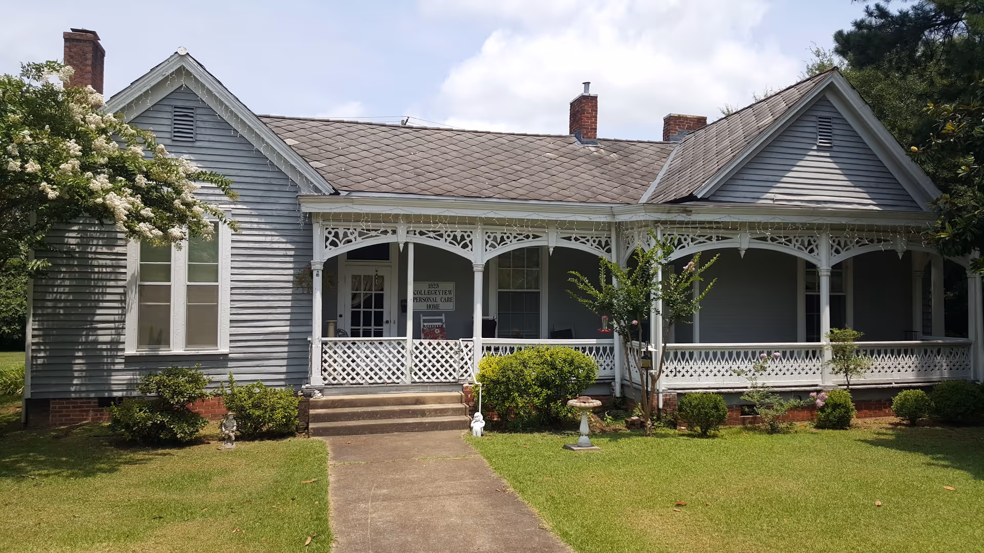 Front exterior of a single-story care home with a decorative wraparound porch.