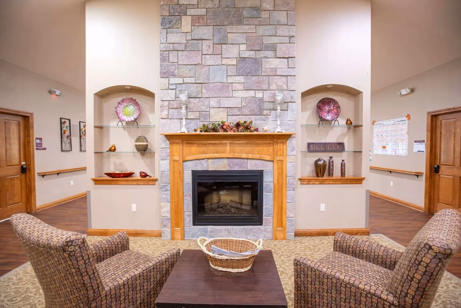 Cozy living room with a stone fireplace, mantle decor, and comfortable seating.