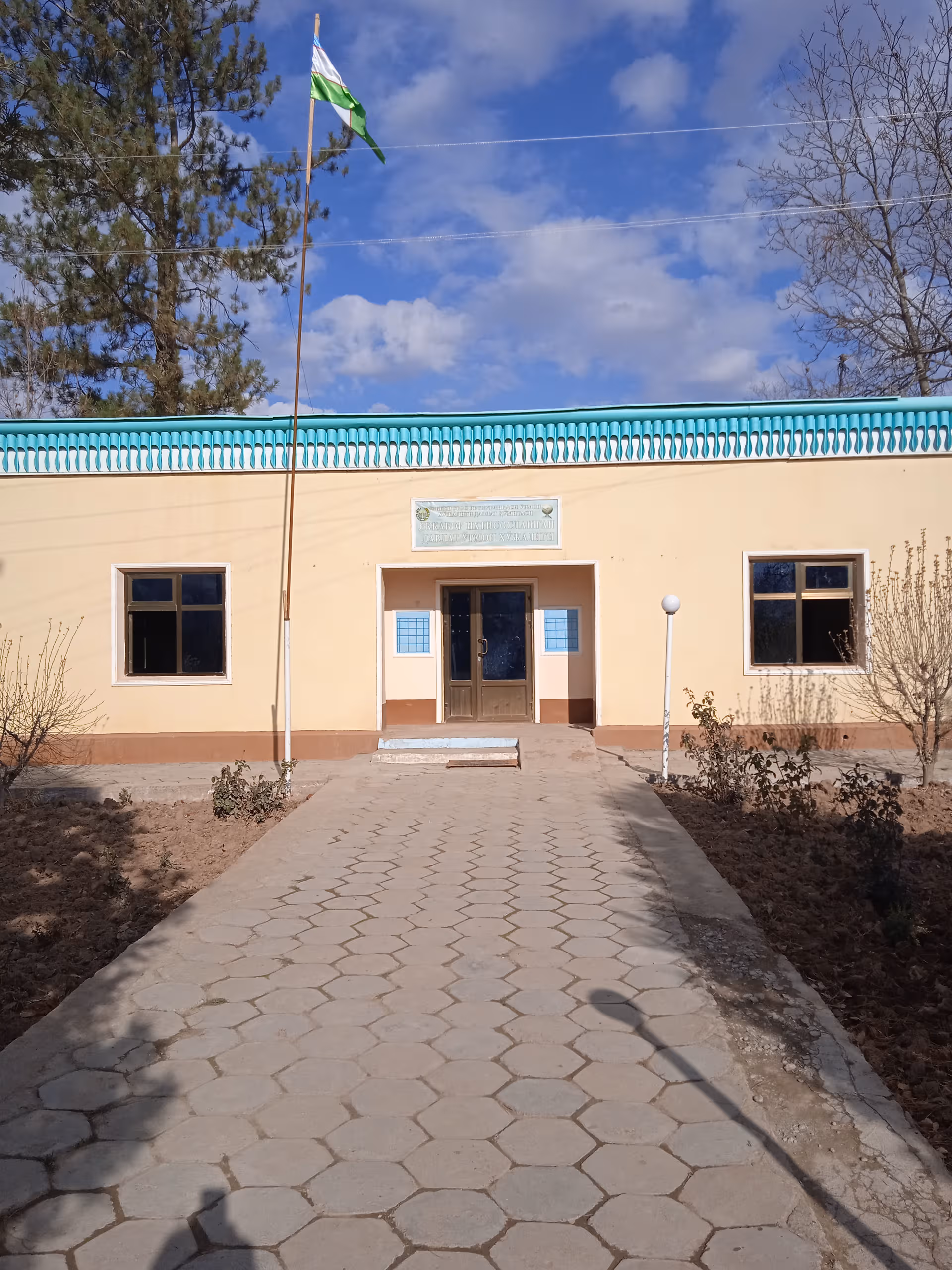 Exterior view of a beige senior facility building with turquoise roof and walkway
