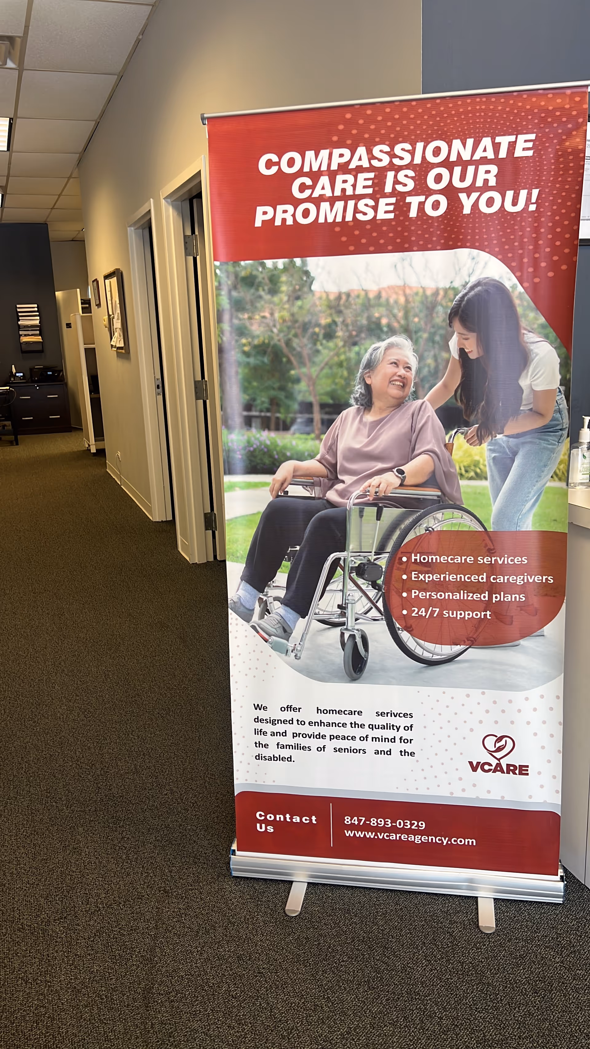 Interior hallway with a large promotional banner featuring a caregiver and an elderly woman.