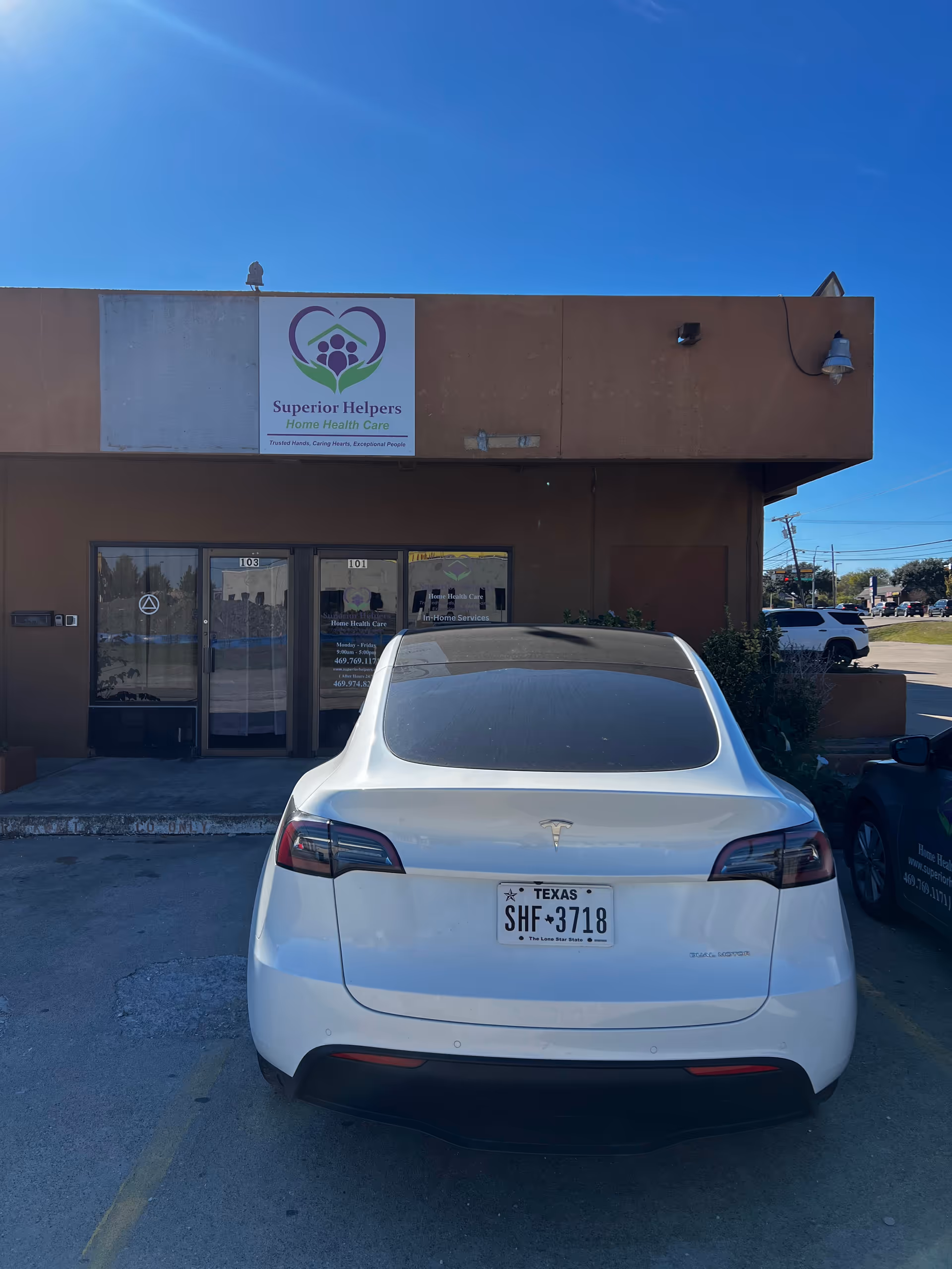 Exterior view of Superior Helpers facility with its sign and a white car parked.