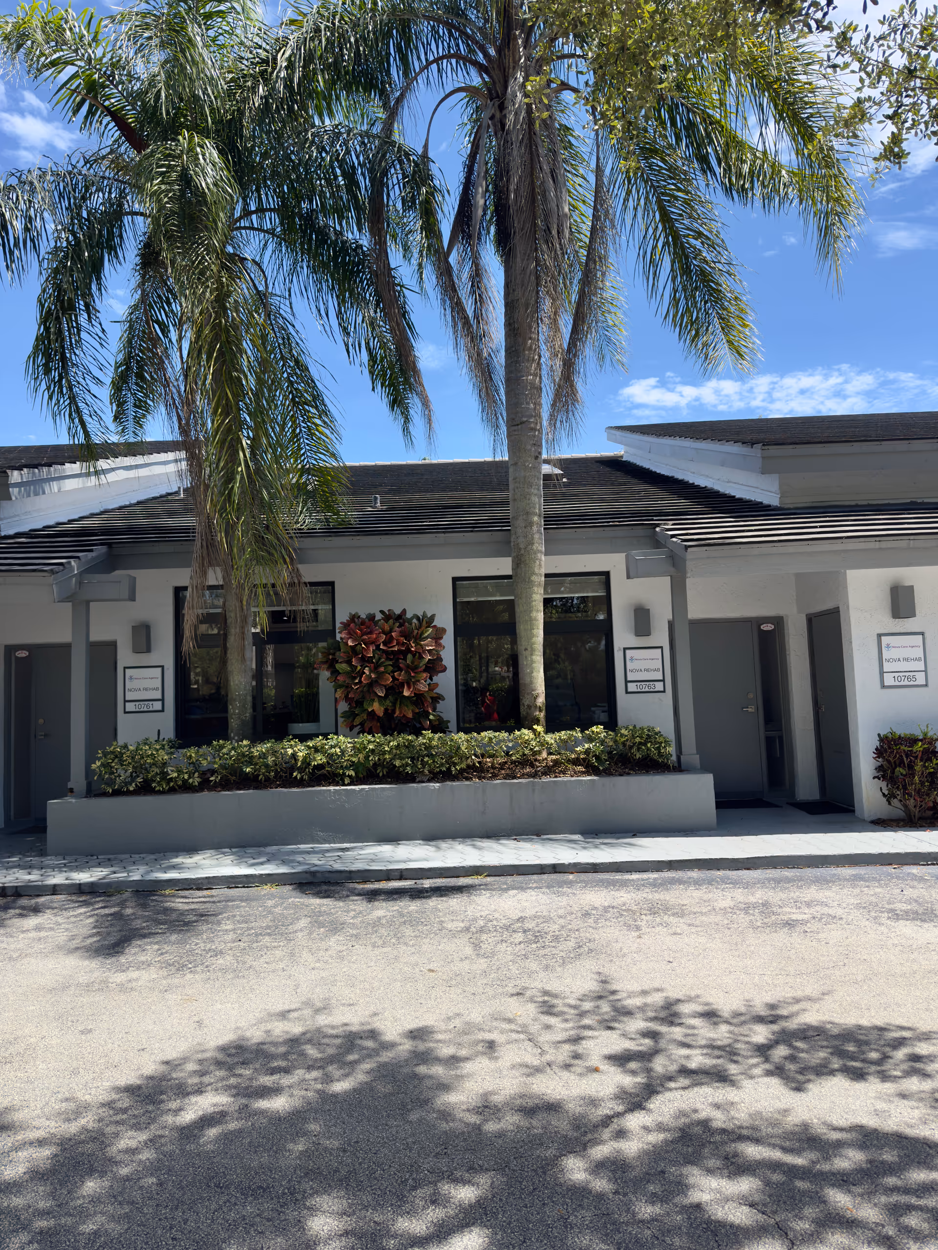 Front exterior of Nova Care Agency and Nova Rehabilitation building with palm trees.