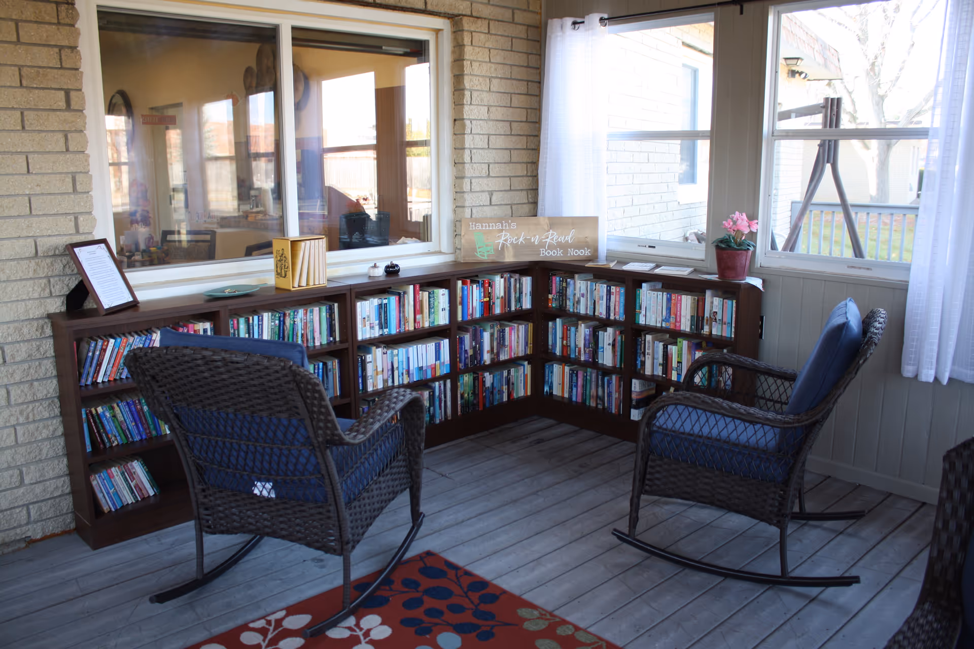 Cozy reading nook with built-in shelves and two wicker rocking chairs indoors.