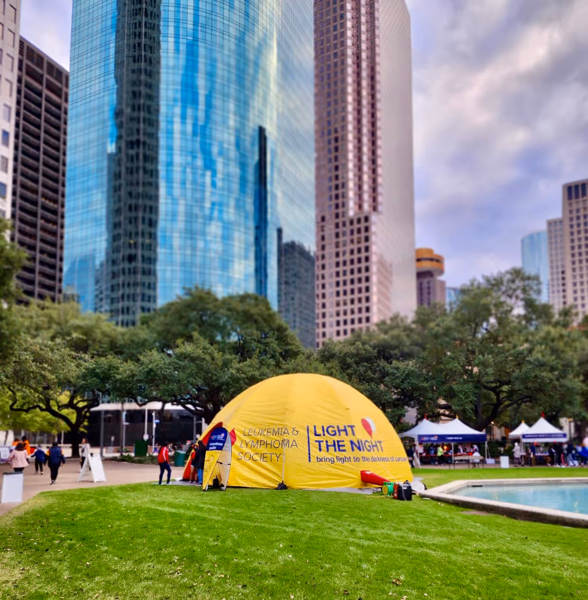 Yellow dome tent with Leukemia and Lymphoma Society signage in a city park.
