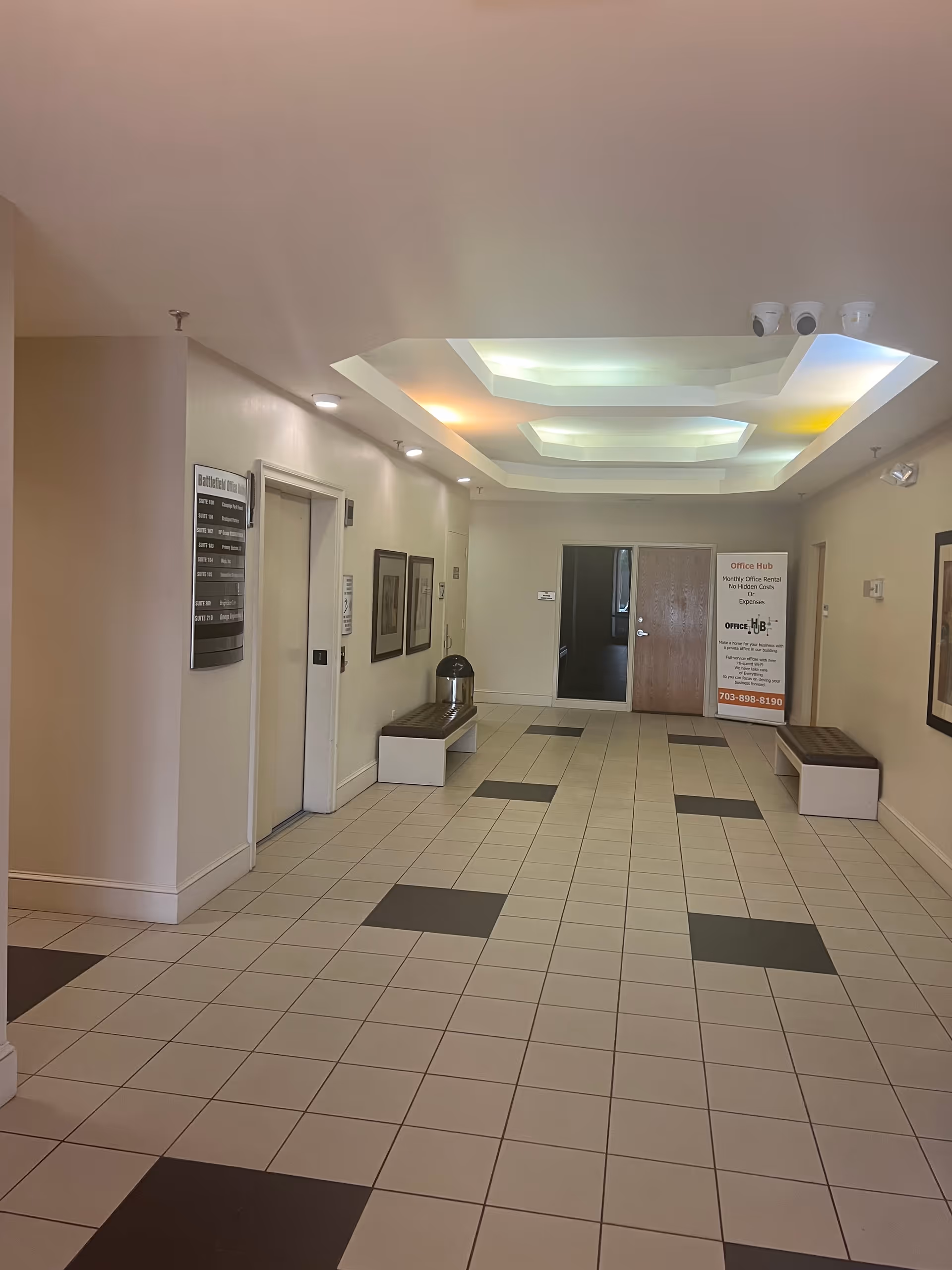 Bright hallway interior with benches and framed art in a senior care facility.