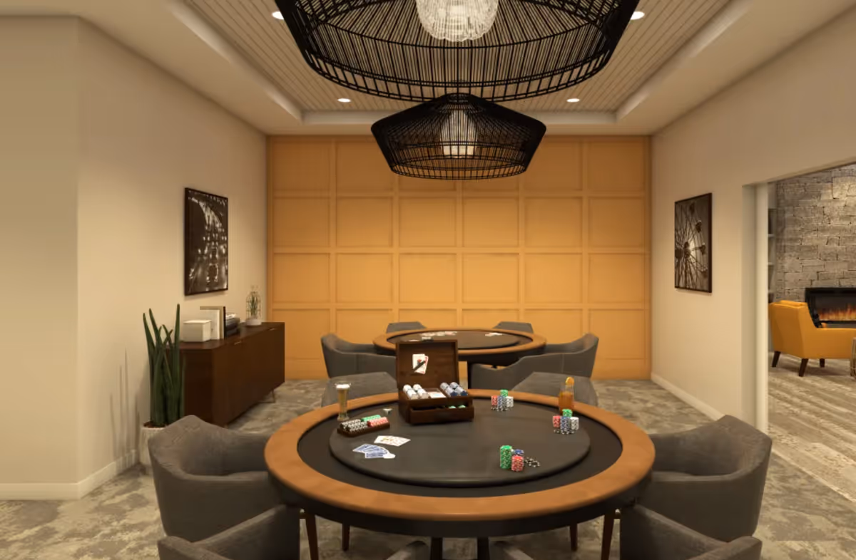 Game room with round poker tables, upholstered chairs, pendant lighting, and a wood-paneled accent wall.