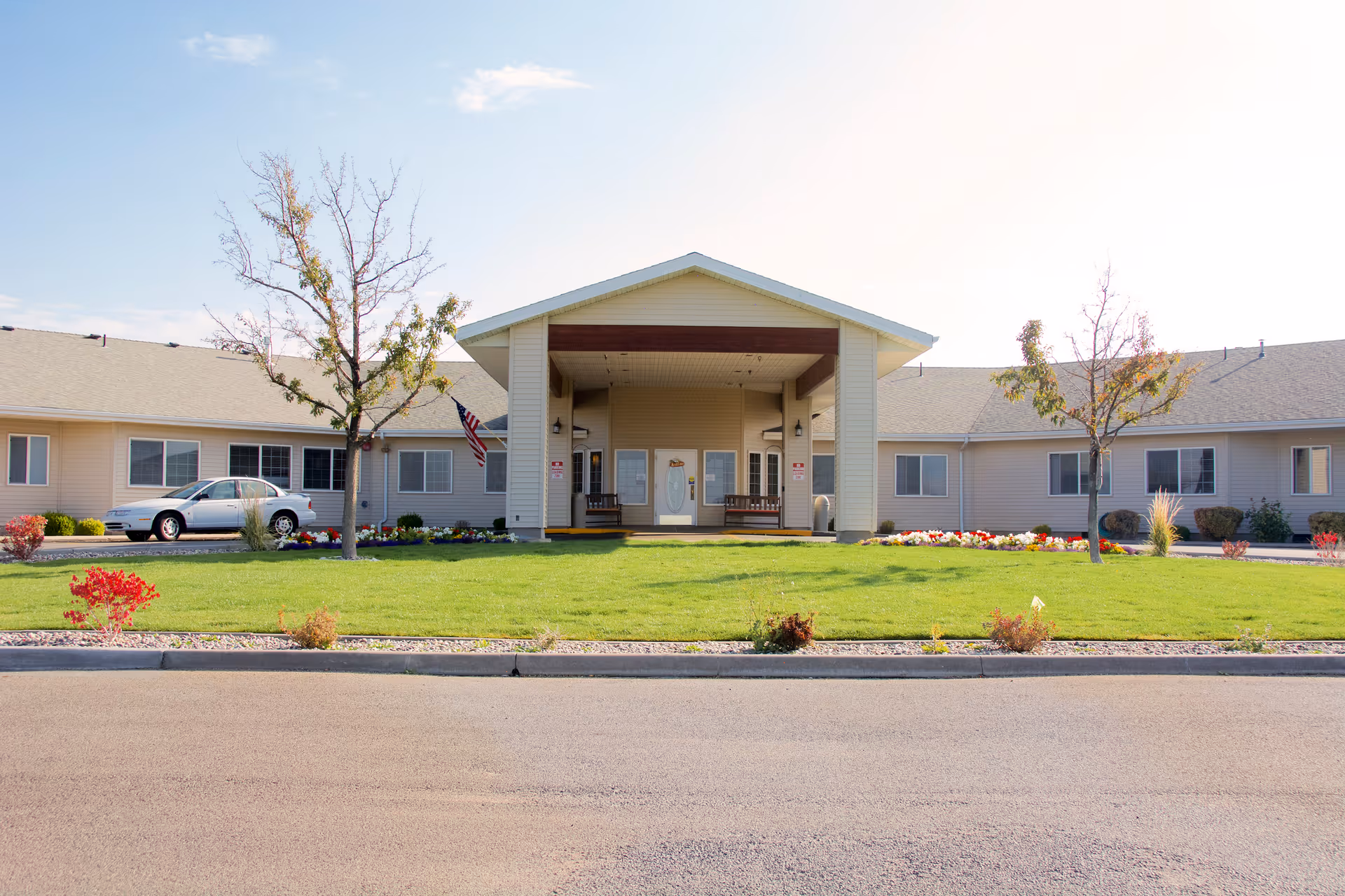 Brookdale Pocatello building exterior with central entrance, lawn, and flower landscaping.