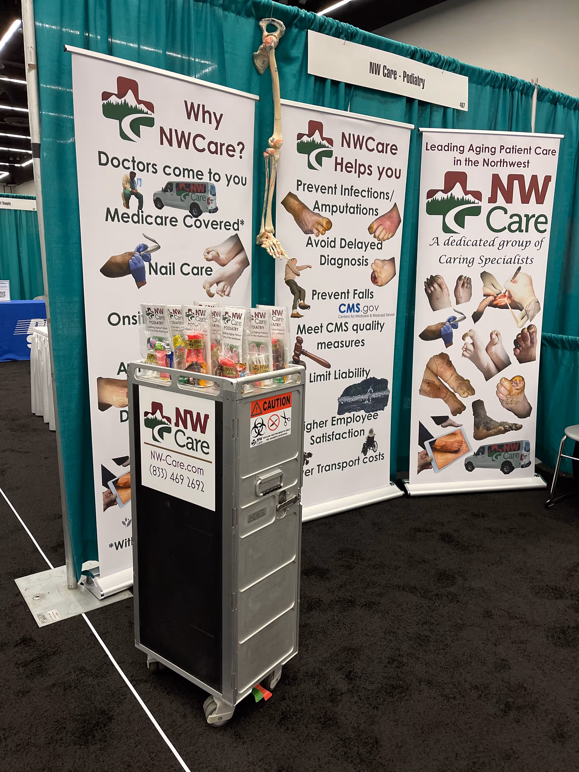 Trade show booth for NW Care Podiatry featuring banners and a wheeled medical cart.