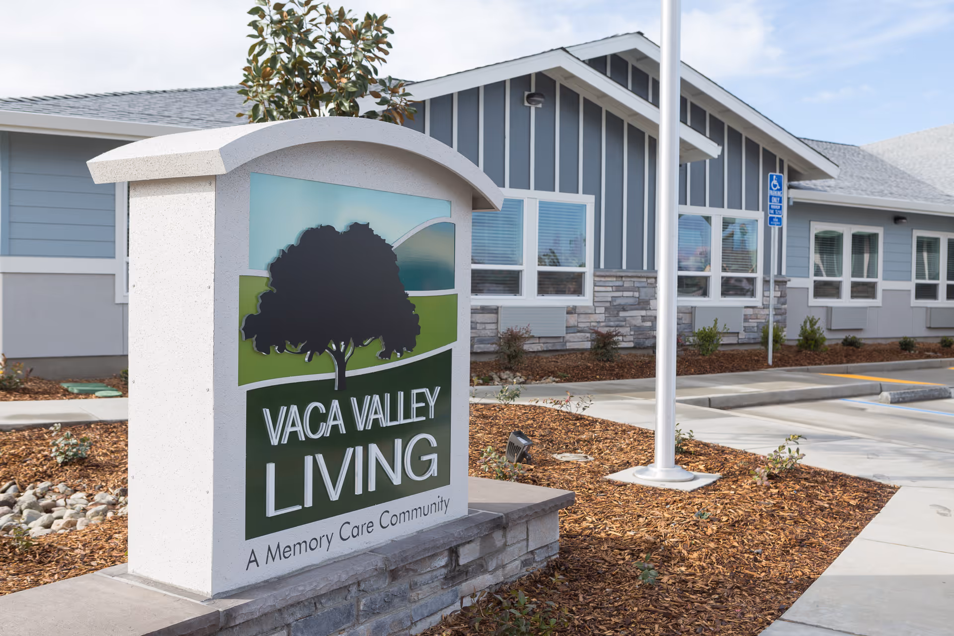 Outdoor view of Vaca Valley Living sign with memory care building exterior.