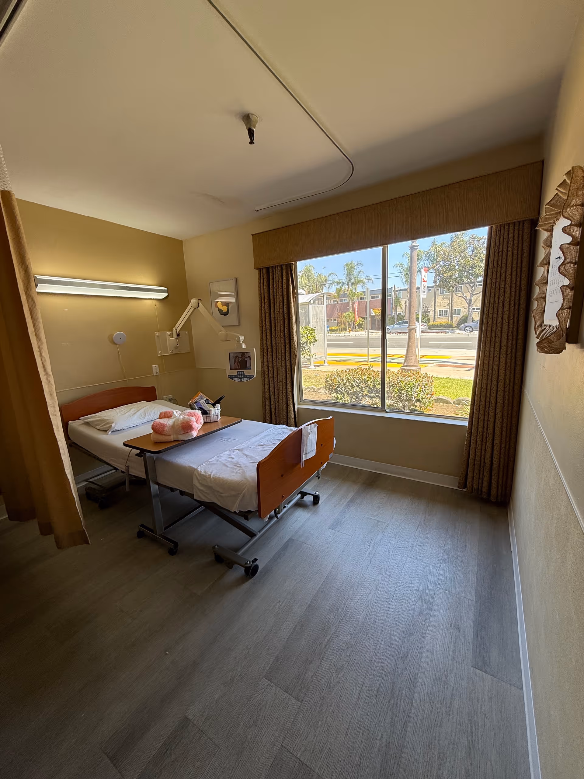 Interior hospital room with adjustable bed, window view, and medical equipment.