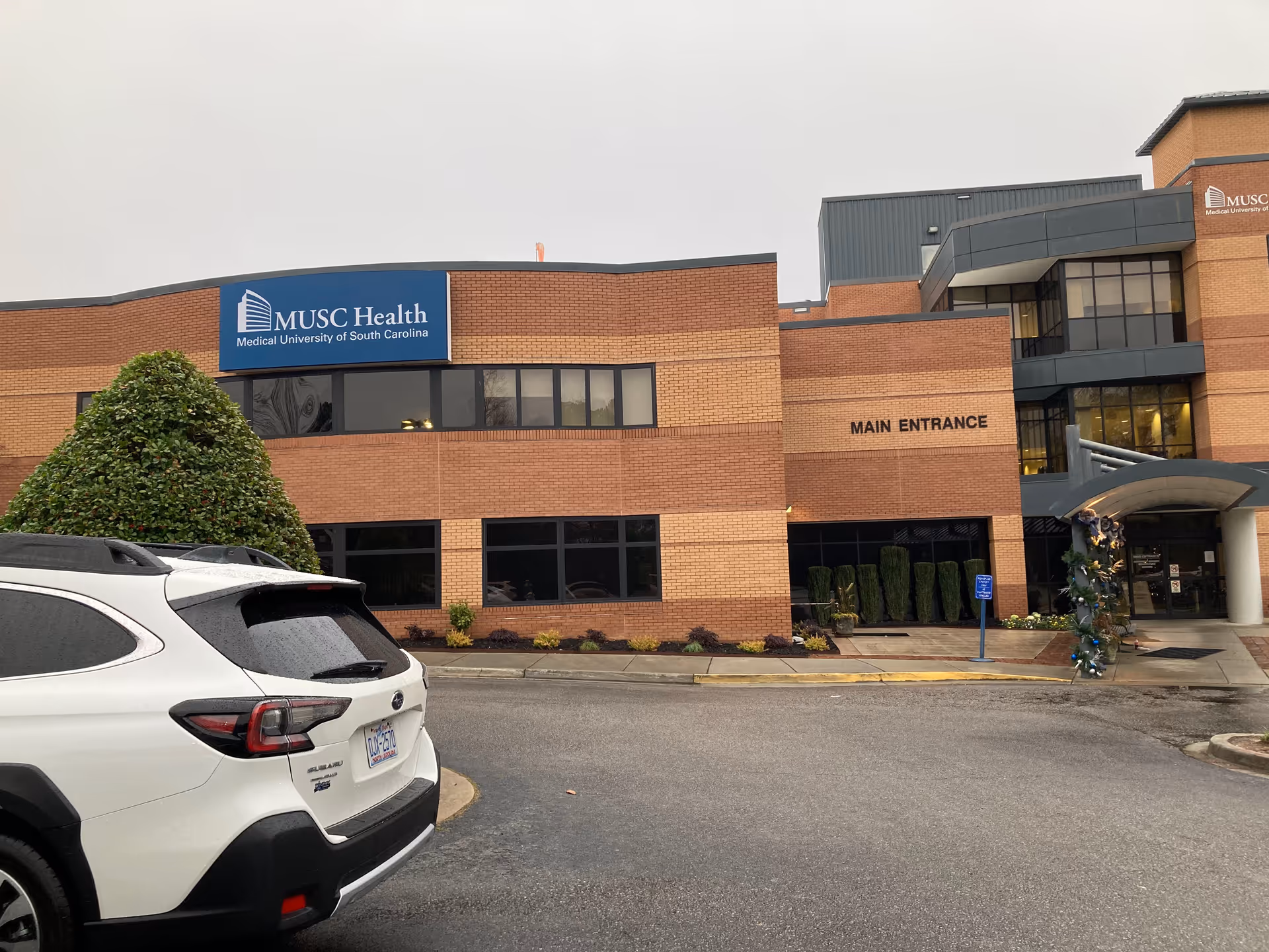 Exterior view of MUSC Health Kershaw Medical Center with main entrance and a parked white SUV