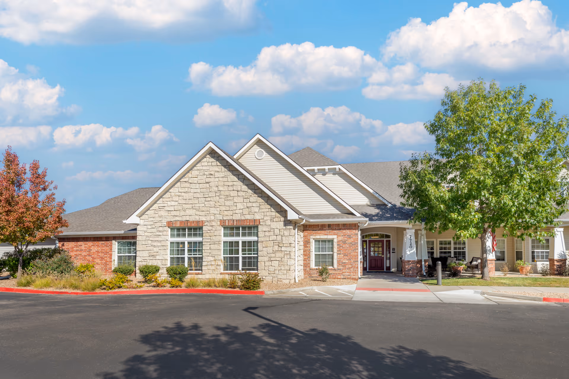 Brookdale Arvada senior living facility exterior front view with stone and brick facade and trees