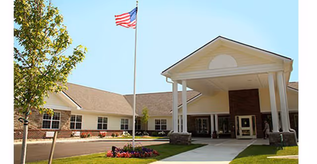 Exterior view of The Villages at Oak Ridge front entrance with flagpole