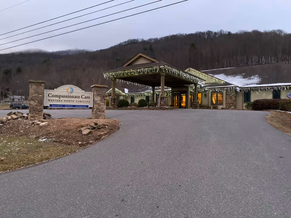 Exterior view of Compassionate Care Western North Carolina entrance with canopy lights and driveway.