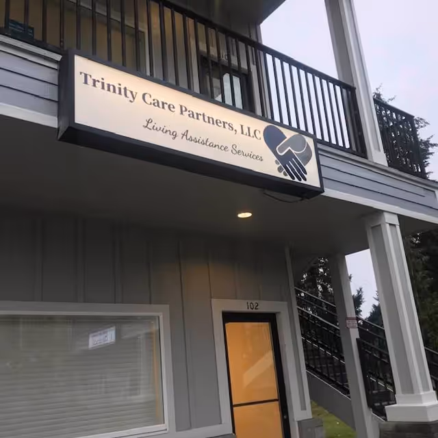 Exterior view shows a Trinity Care Partners facility with sign and railing.