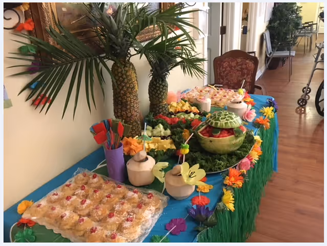 Colorful tropical fruit buffet set up on a serving table in a facility hallway.