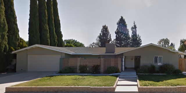 Front exterior of a single-story care facility with a lawn and driveway.