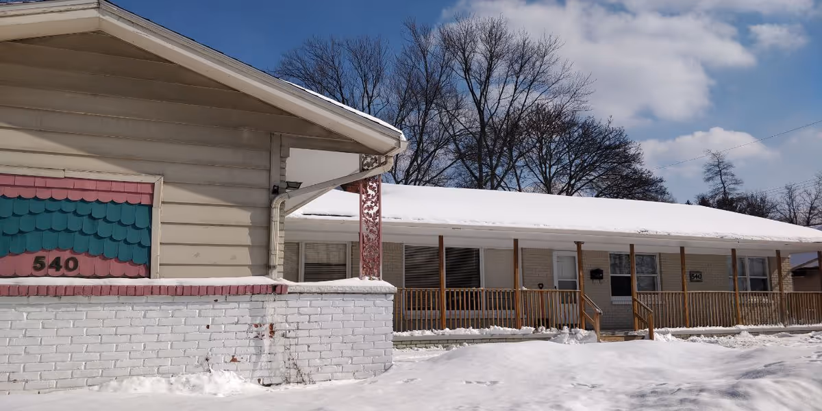 Exterior view of a single-story senior living facility with a snow-covered porch.