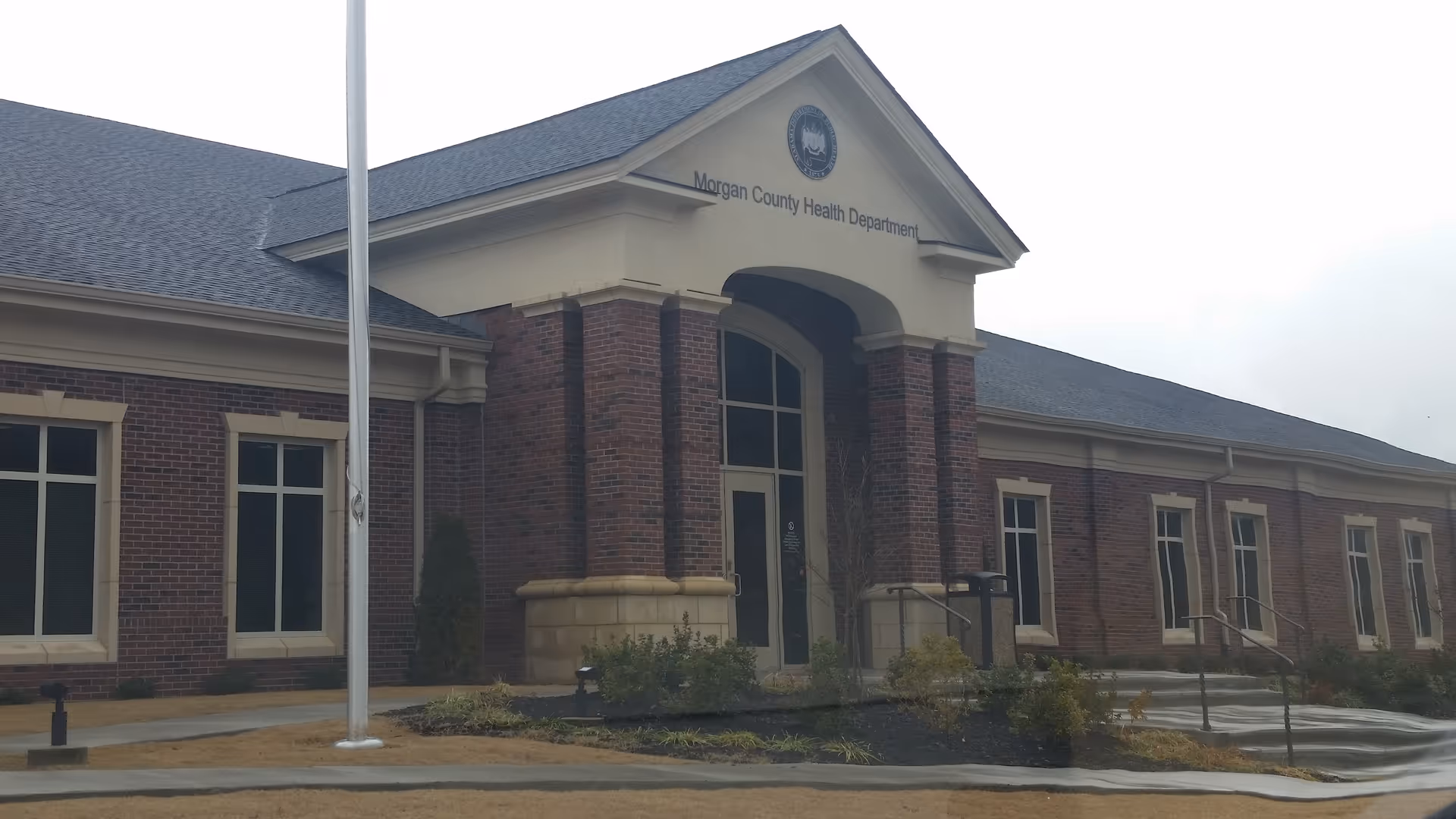 Exterior view of a brick Morgan County Health Department building with a covered entrance.