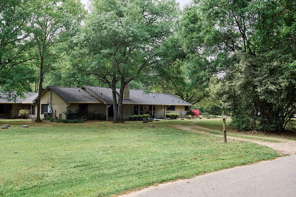 TheSilverfield single-story building fronts a lush, tree-filled lawn exterior.
