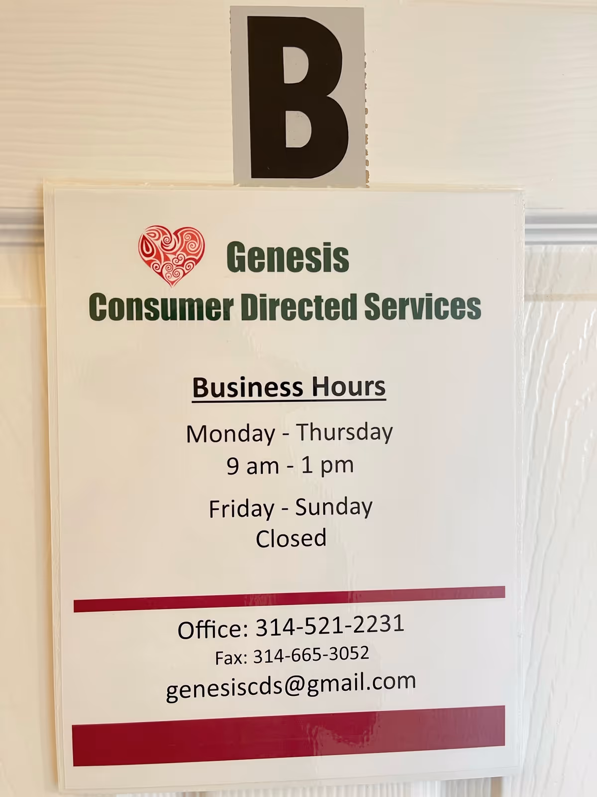 Indoor wall with a Genesis Consumer Directed Services sign and business hours display.