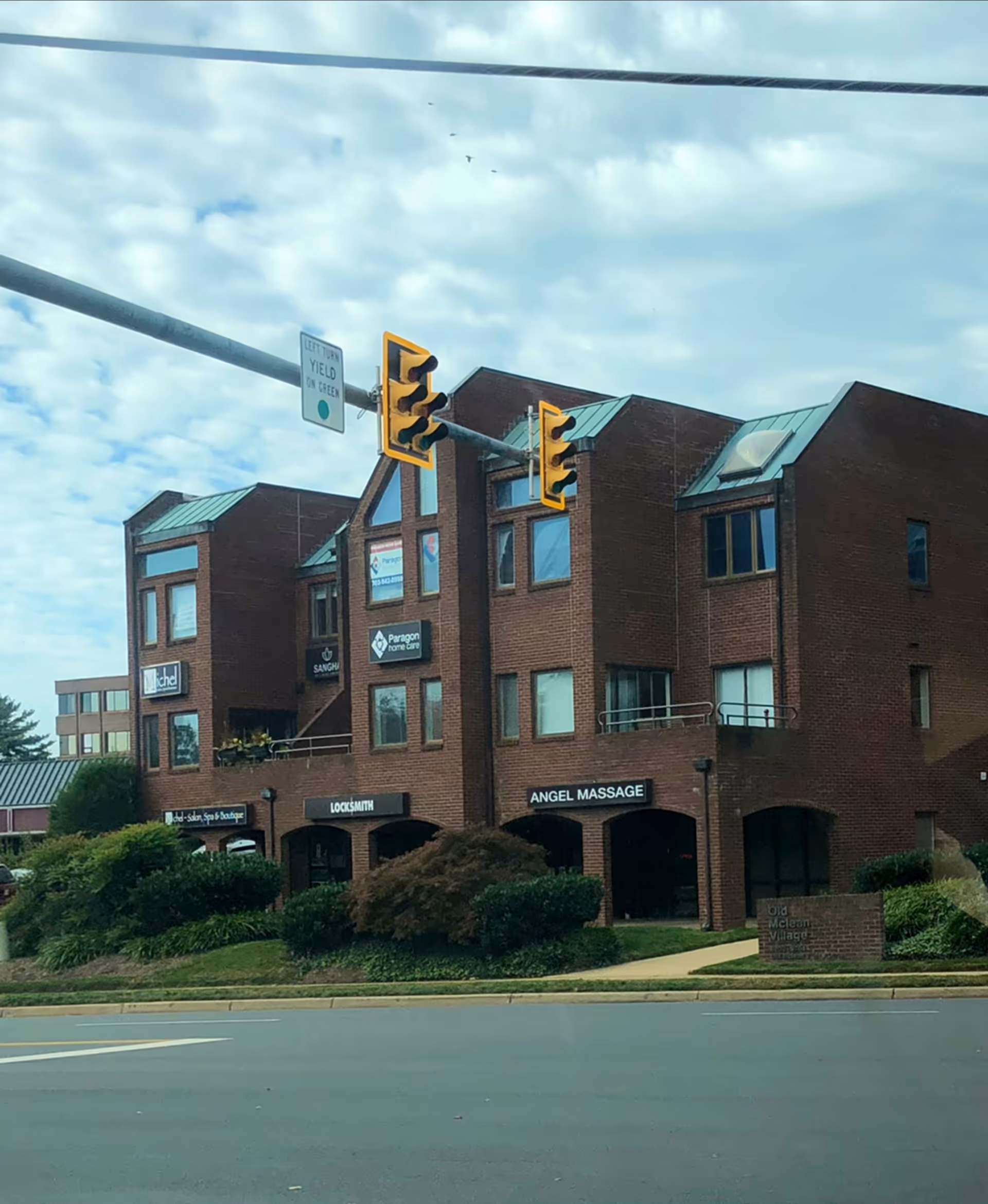 Brick, multi-unit building with Paragon Home Care sign and storefronts along a street.