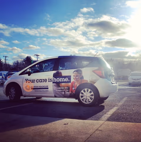 Guardian Healthcare promotional van parked in a lot under a partly cloudy sky.