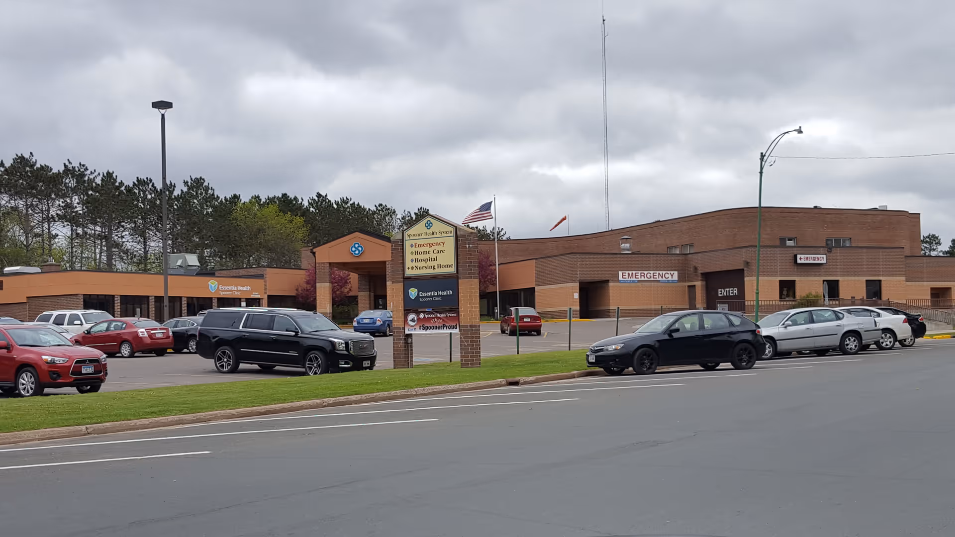 Spooner Health exterior with parking lot and emergency entrance signs