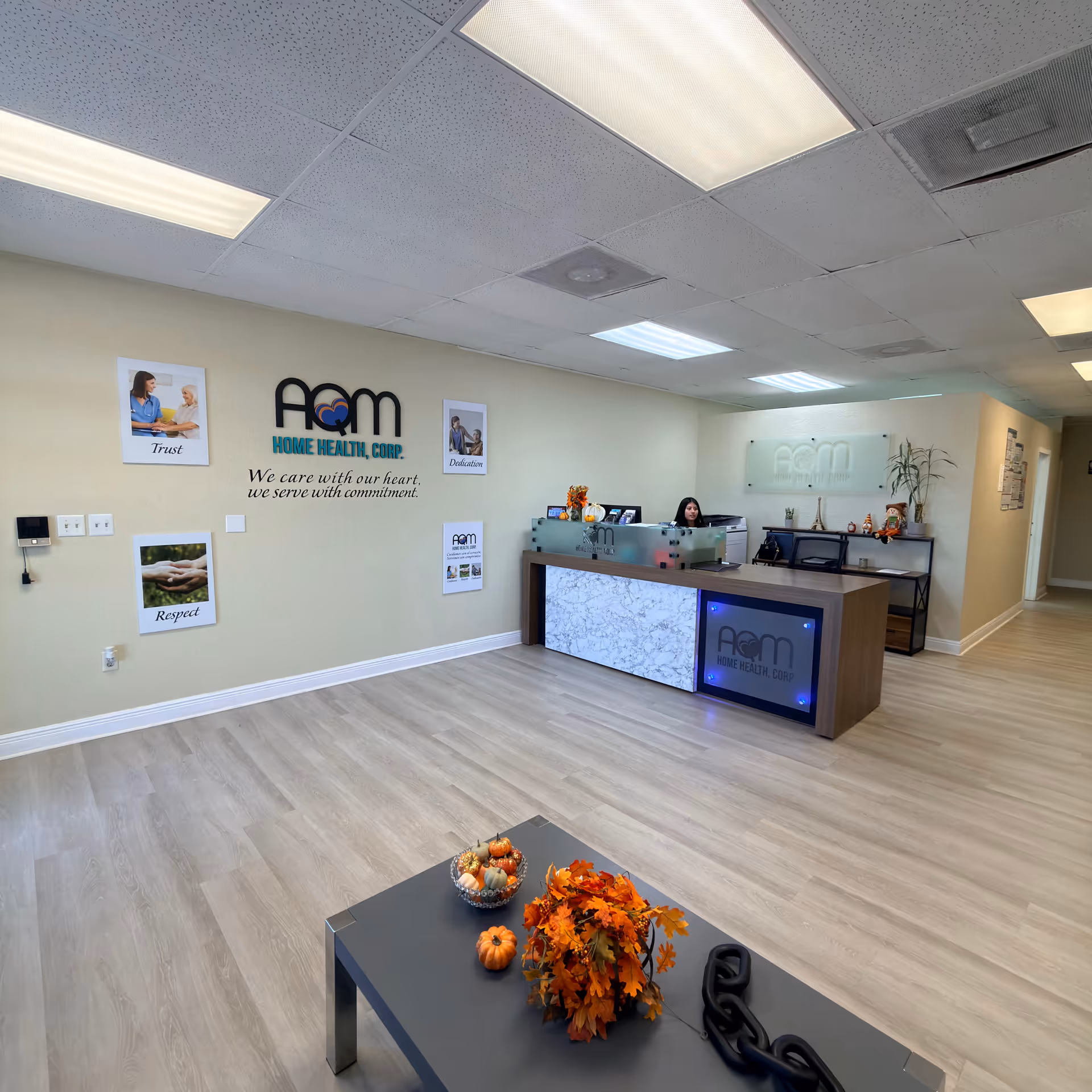 Reception area of AQM Home Health Corp with front desk and autumn decor.